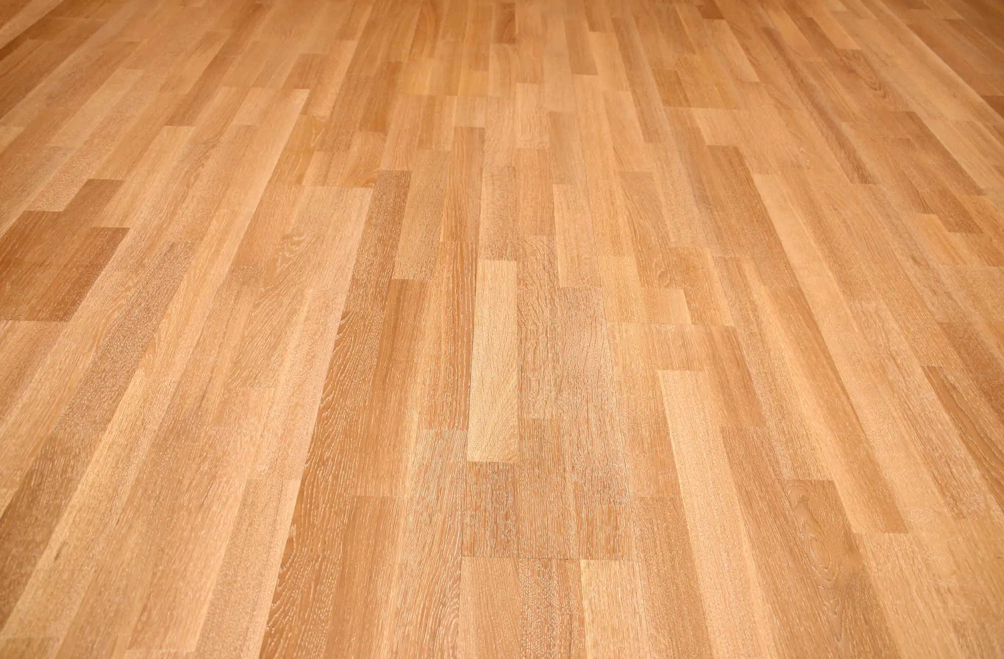 Light brown wooden floor features a smooth, polished surface with visible grain patterns in various shades.