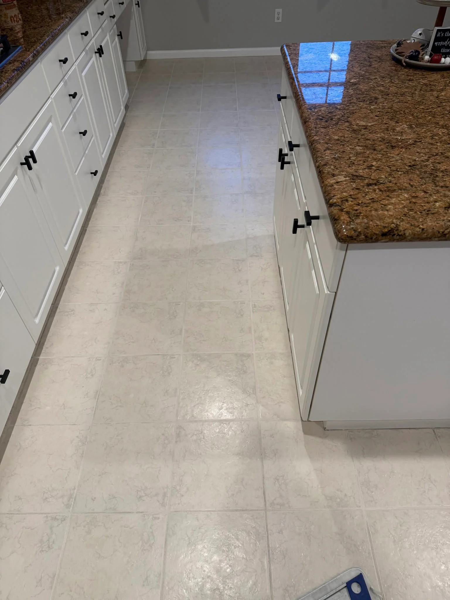 Bright kitchen with white cabinets, tan granite countertops, and light tile flooring for modern homes.